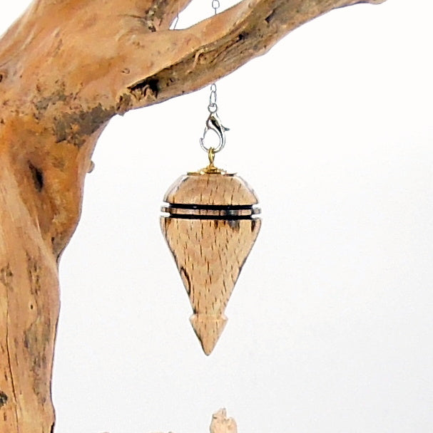 Pendule artisanal de radiesthésie en hêtre échauffé avec chainette et coupelle dorée.