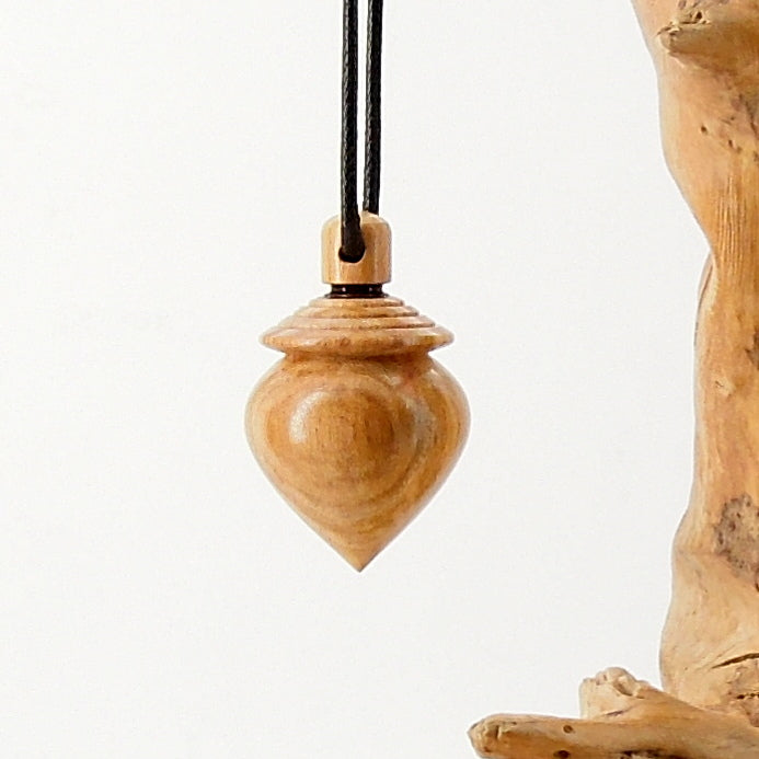 Pendule artisanal de radiesthésie en pêcher avec oeilleton.