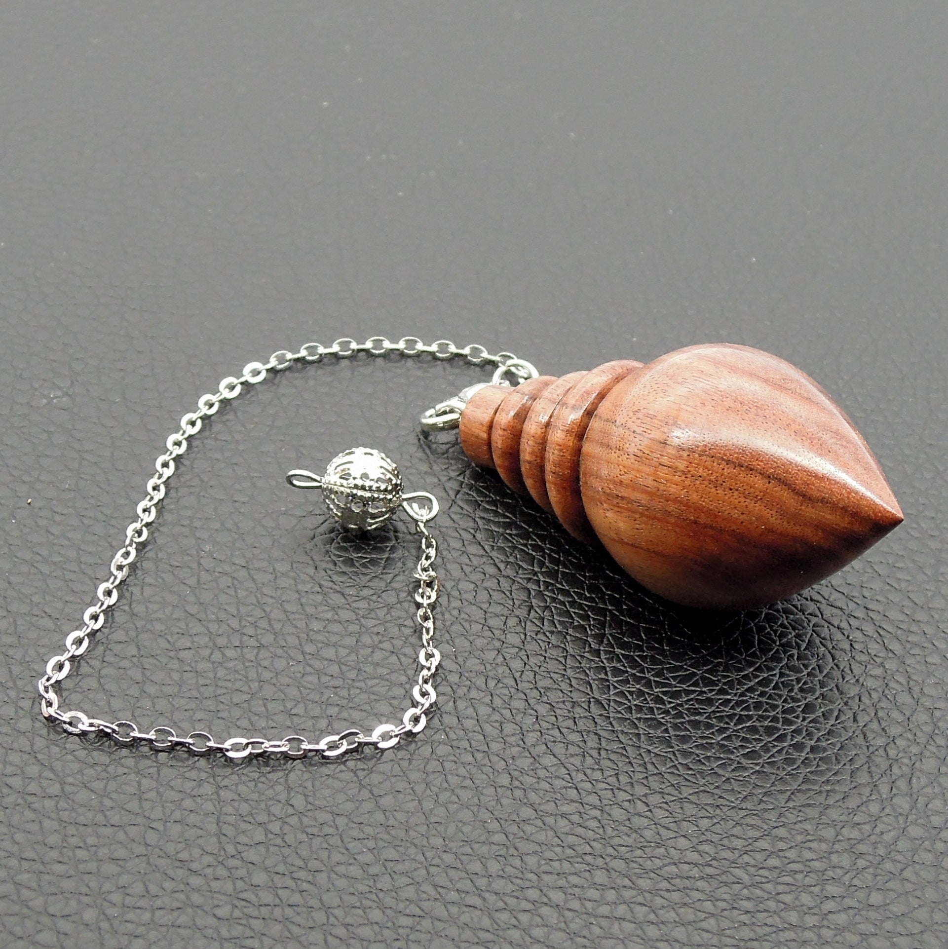 Pendule artisanal de radiesthésie en palissandre santos avec chainette.