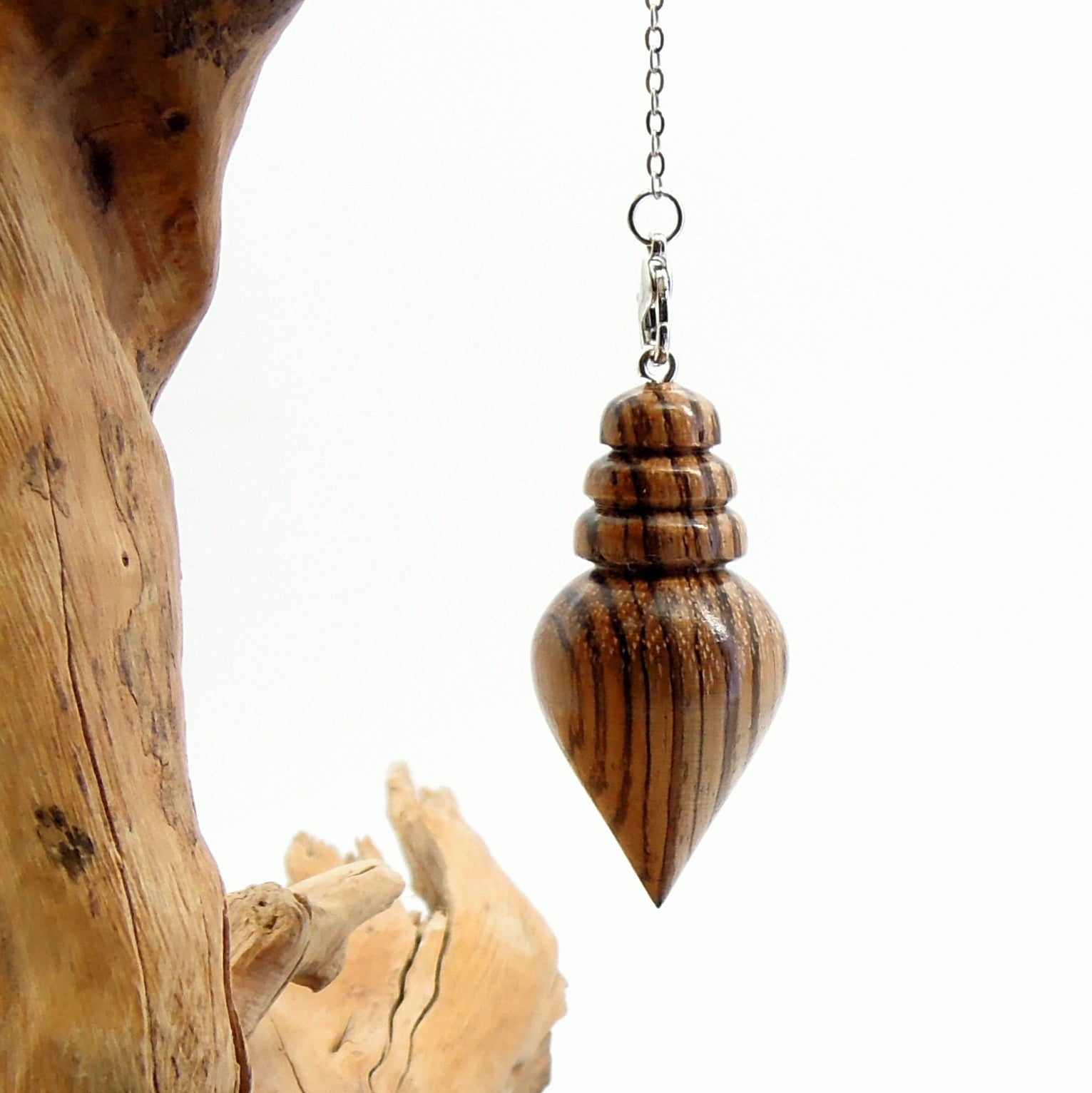 Pendule artisanal de radiesthésie en zébrano avec chainette.