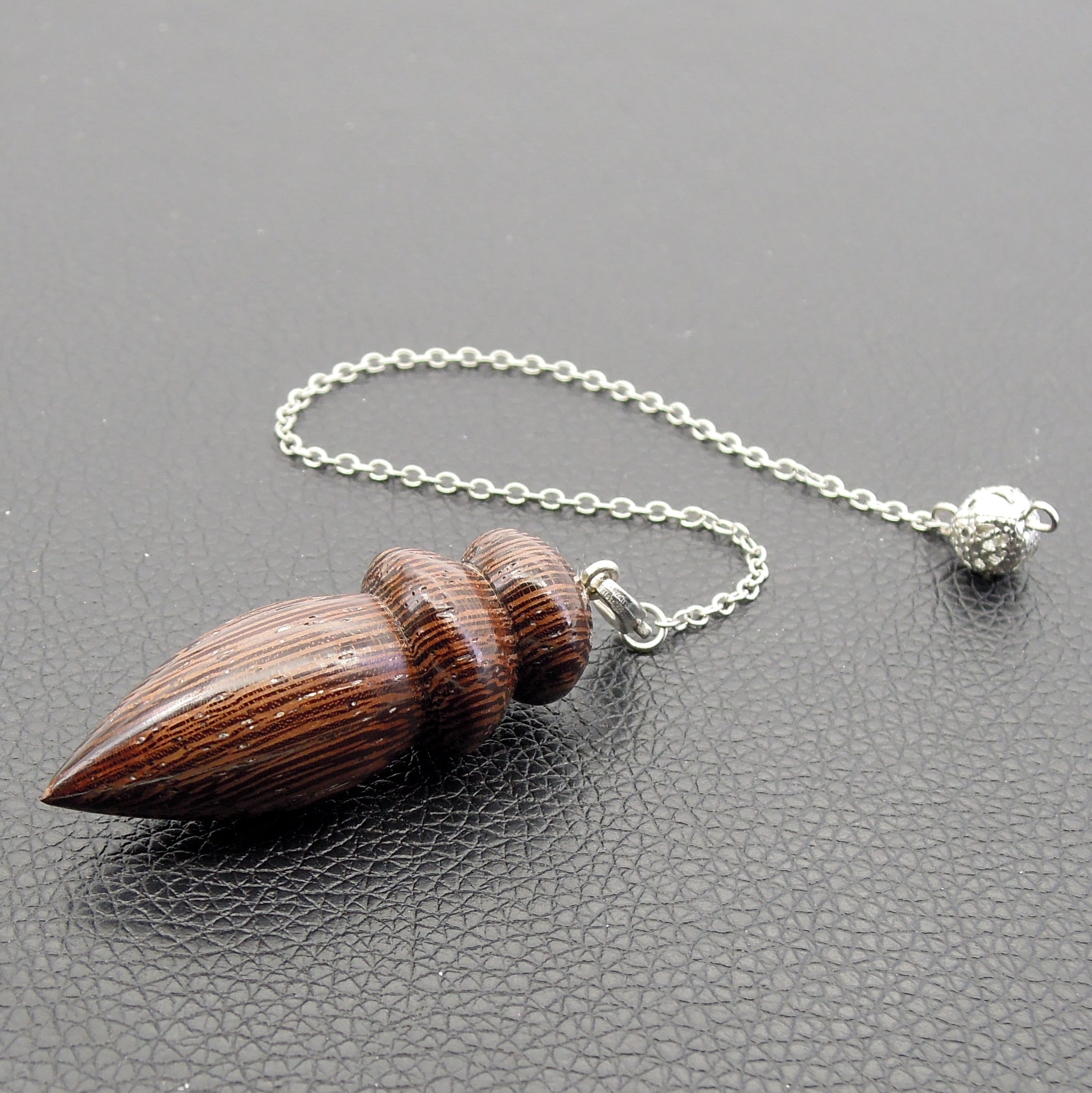 Pendule de radiesthésie en bois exotique.