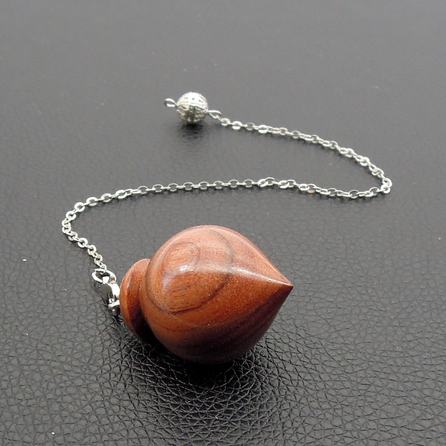 Pendule artisanal de radiesthésie en palissandre santos avec chainette.