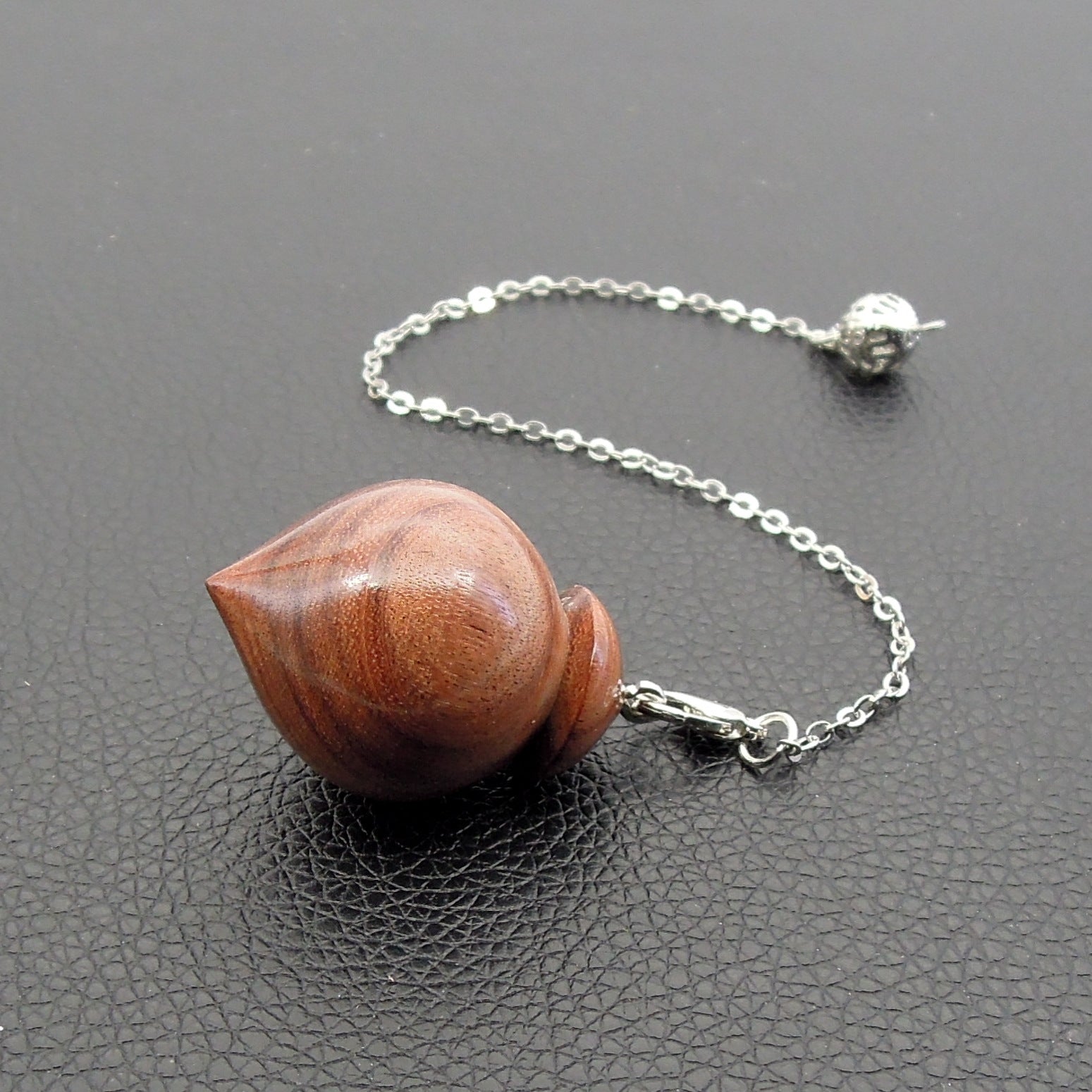 Pendule artisanal de radiesthésie en palissandre santos avec chainette.