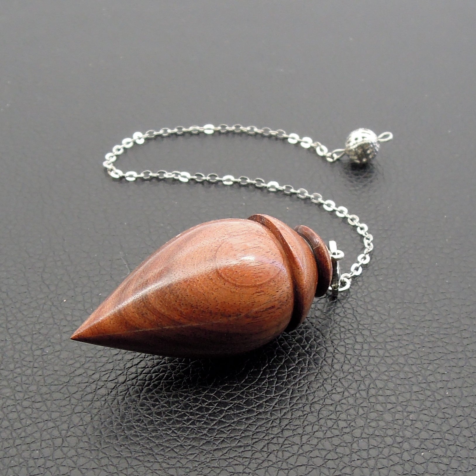 Pendule artisanal de radiesthésie en palissandre santos avec chainette.