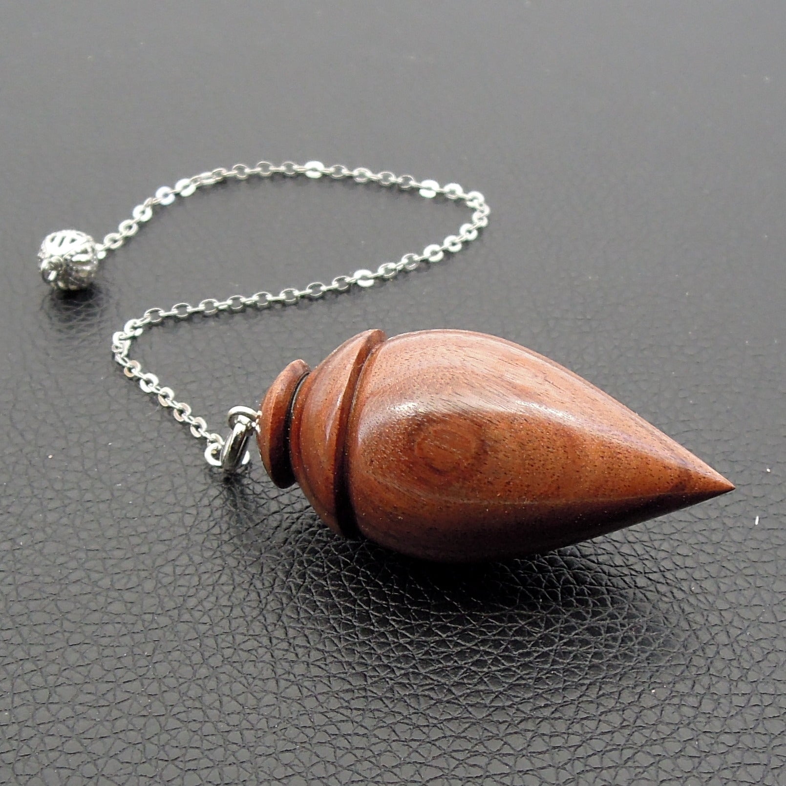 Pendule artisanal de radiesthésie en palissandre santos avec chainette.