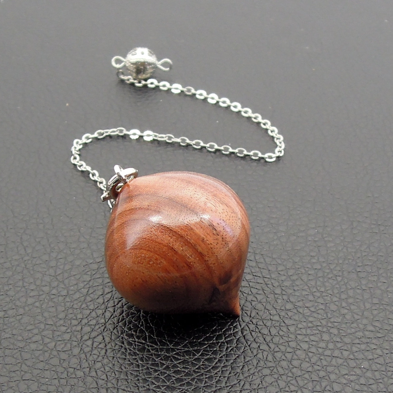 Pendule artisanal de radiesthésie en palissandre santos avec chainette.