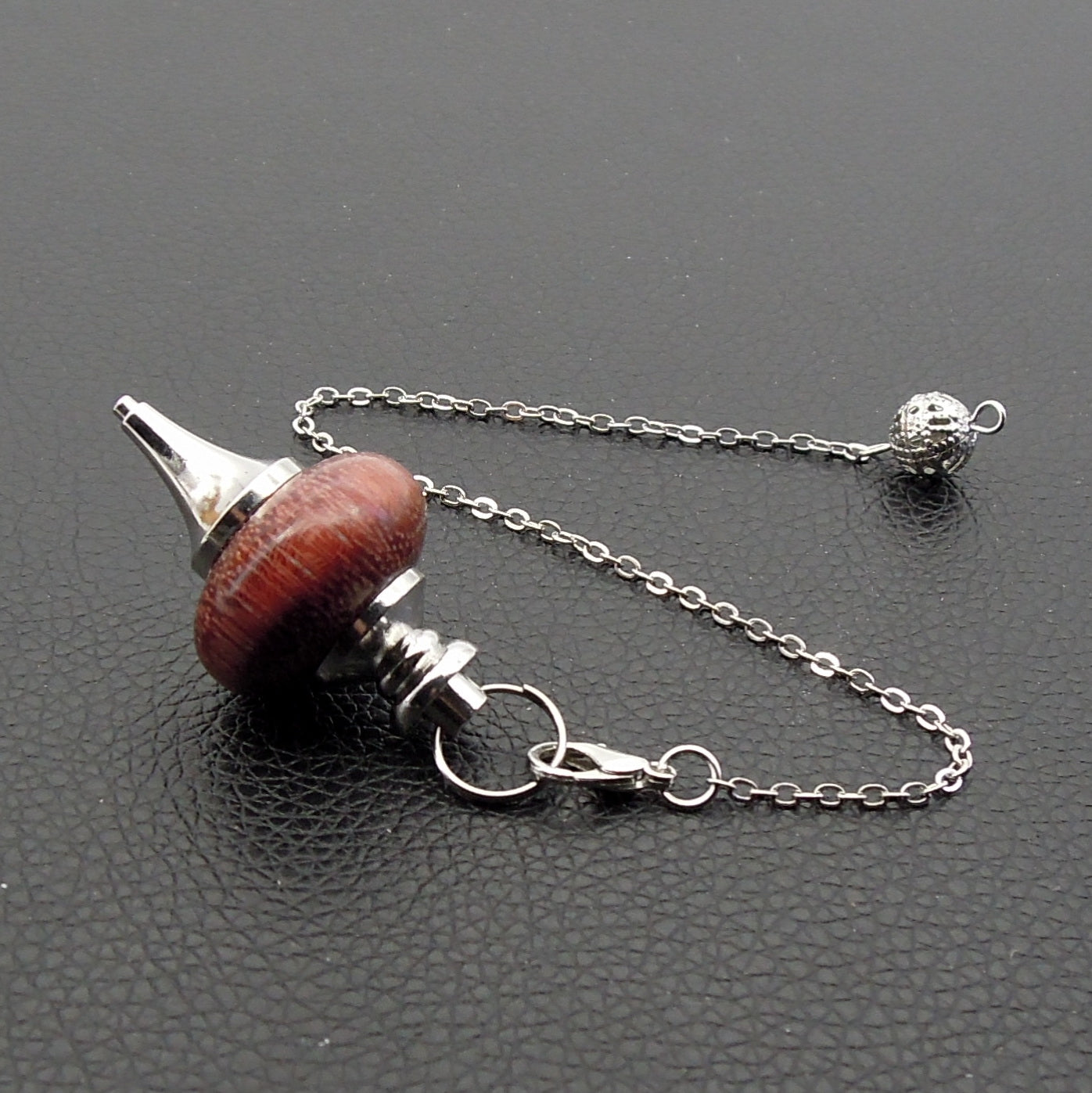 Pendule artisanal de radiesthésie en amarante avec chainette et monture métal.
