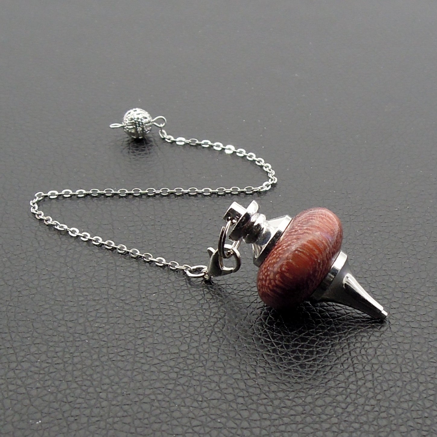 Pendule artisanal de radiesthésie en amarante avec chainette et monture métal.