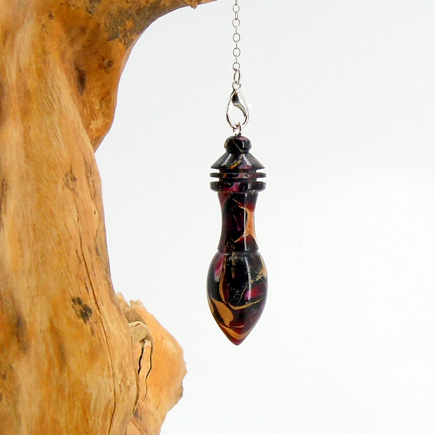 Pendule artisanal divinatoire en résine et inserts végétaux.