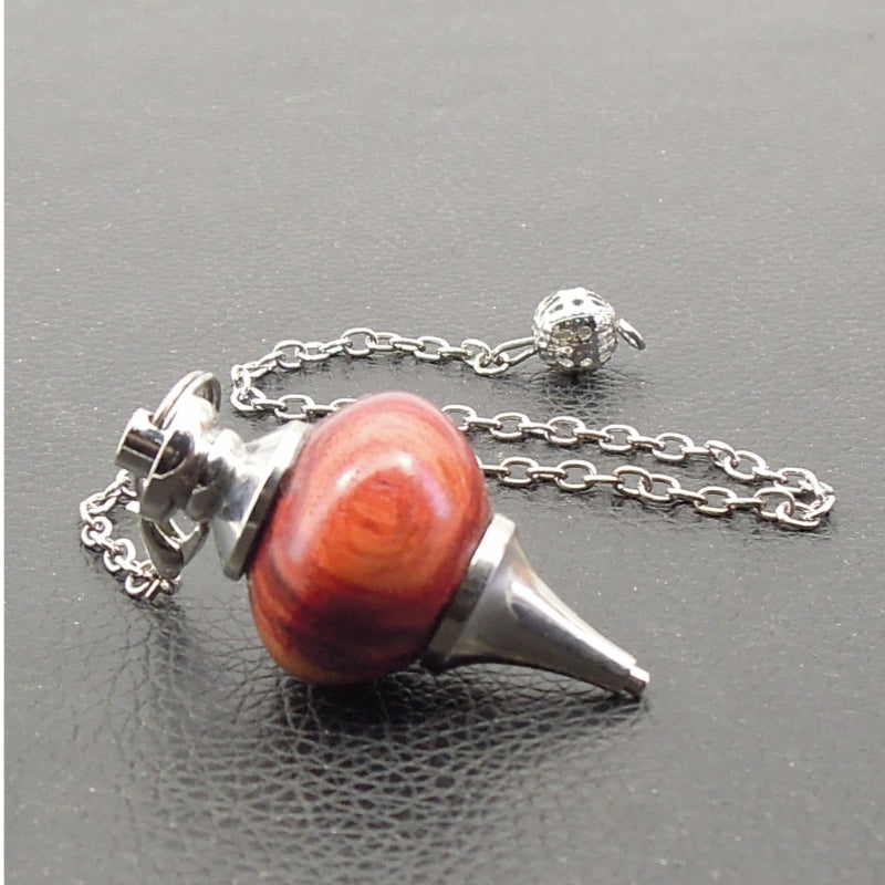 Pendule artisanal de radiesthésie en bois de rose avec chainette et monture métal.