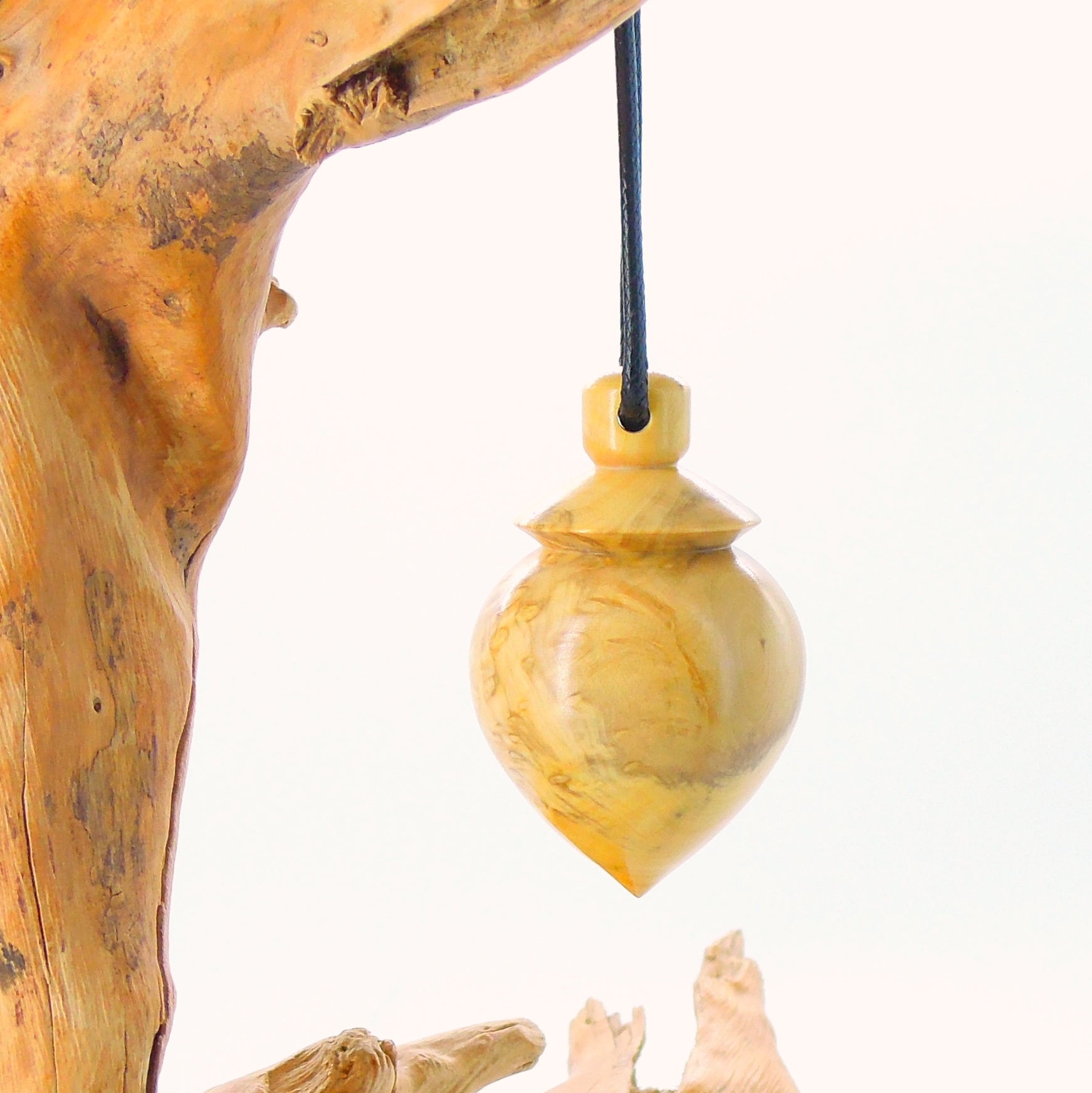 Pendule artisanal de radiesthésie en loupe de buis avec oeilleton.
