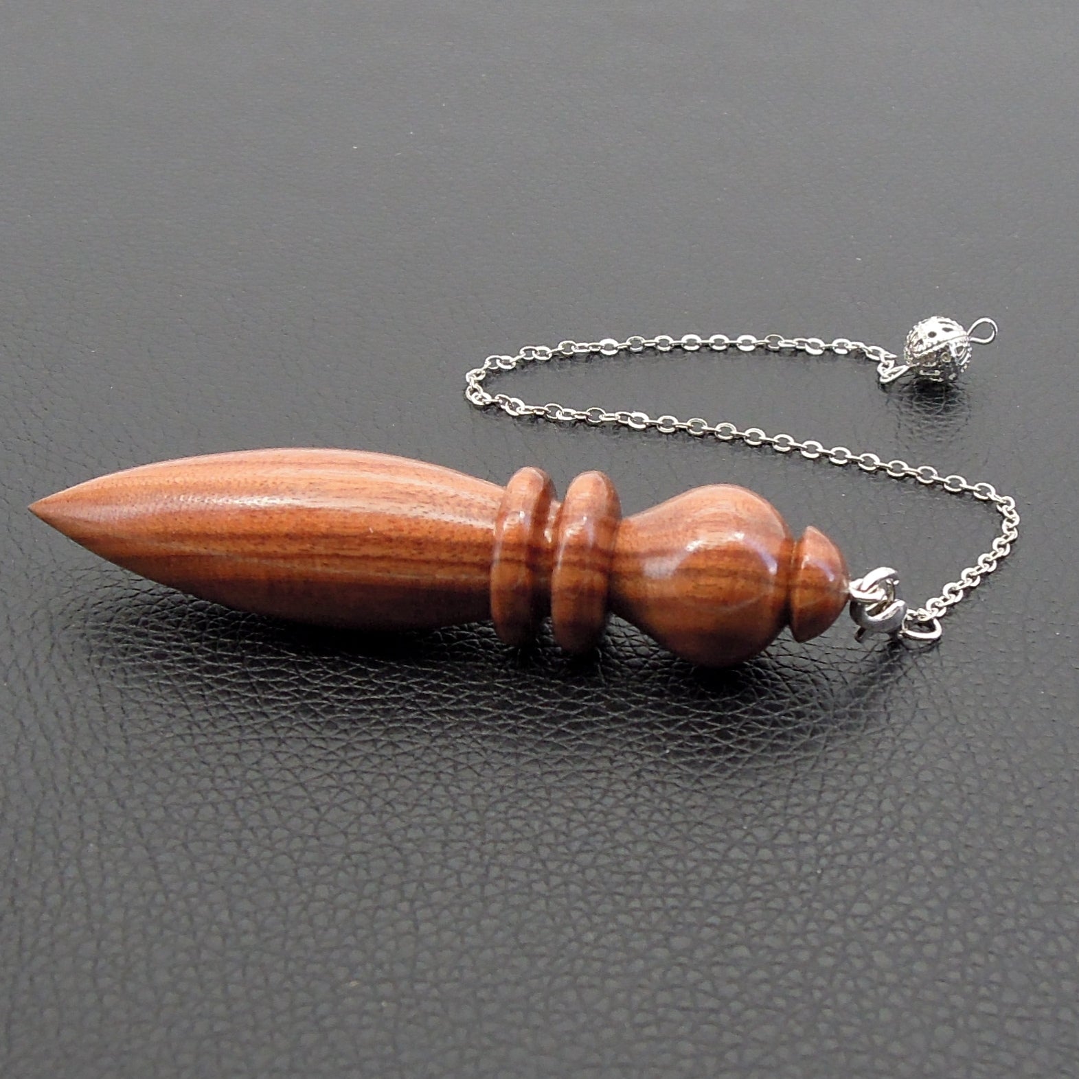 Pendule artisanal de radiesthésie en palissandre santos avec chainette.