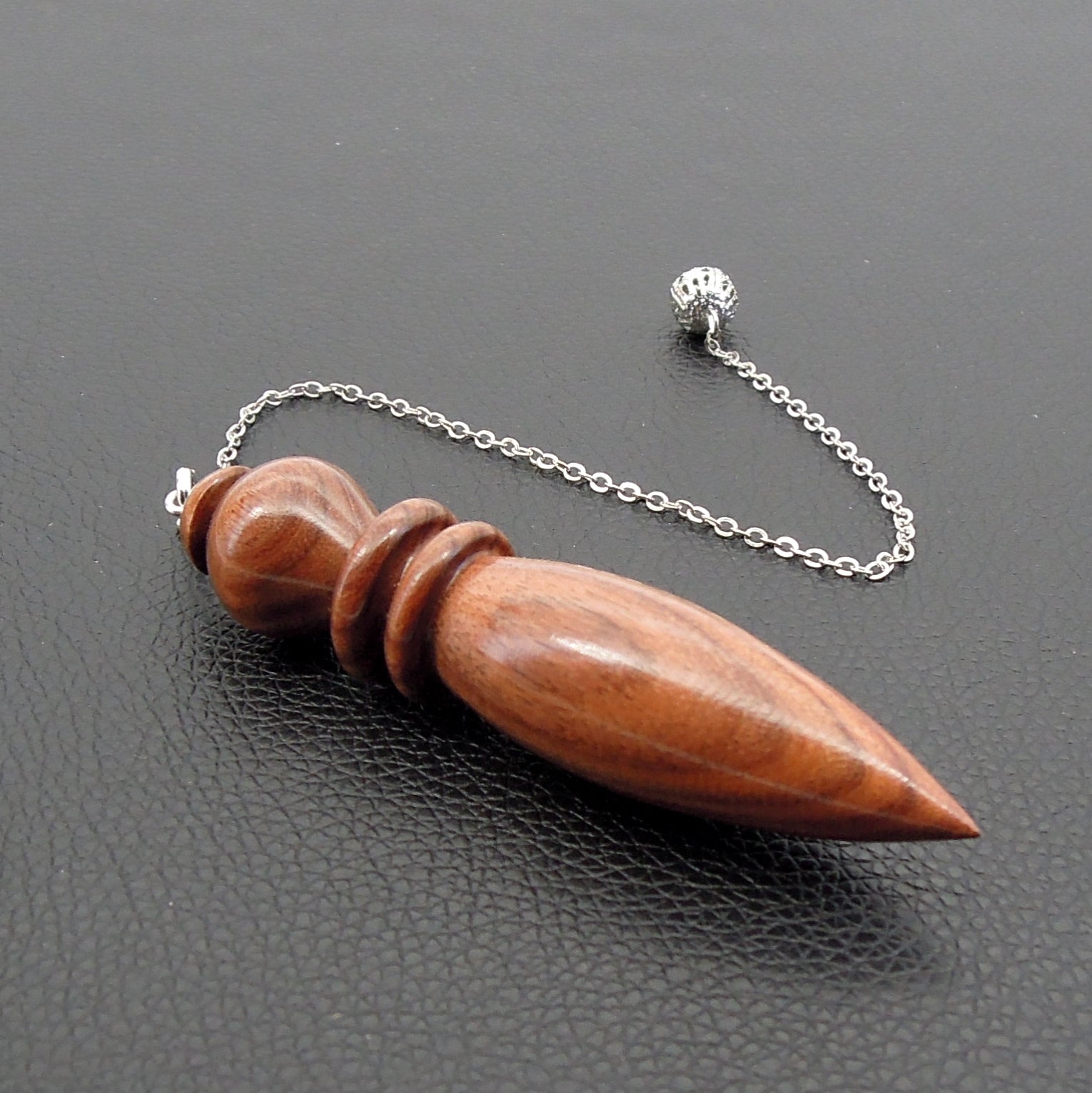 Pendule artisanal de radiesthésie en palissandre santos avec chainette.
