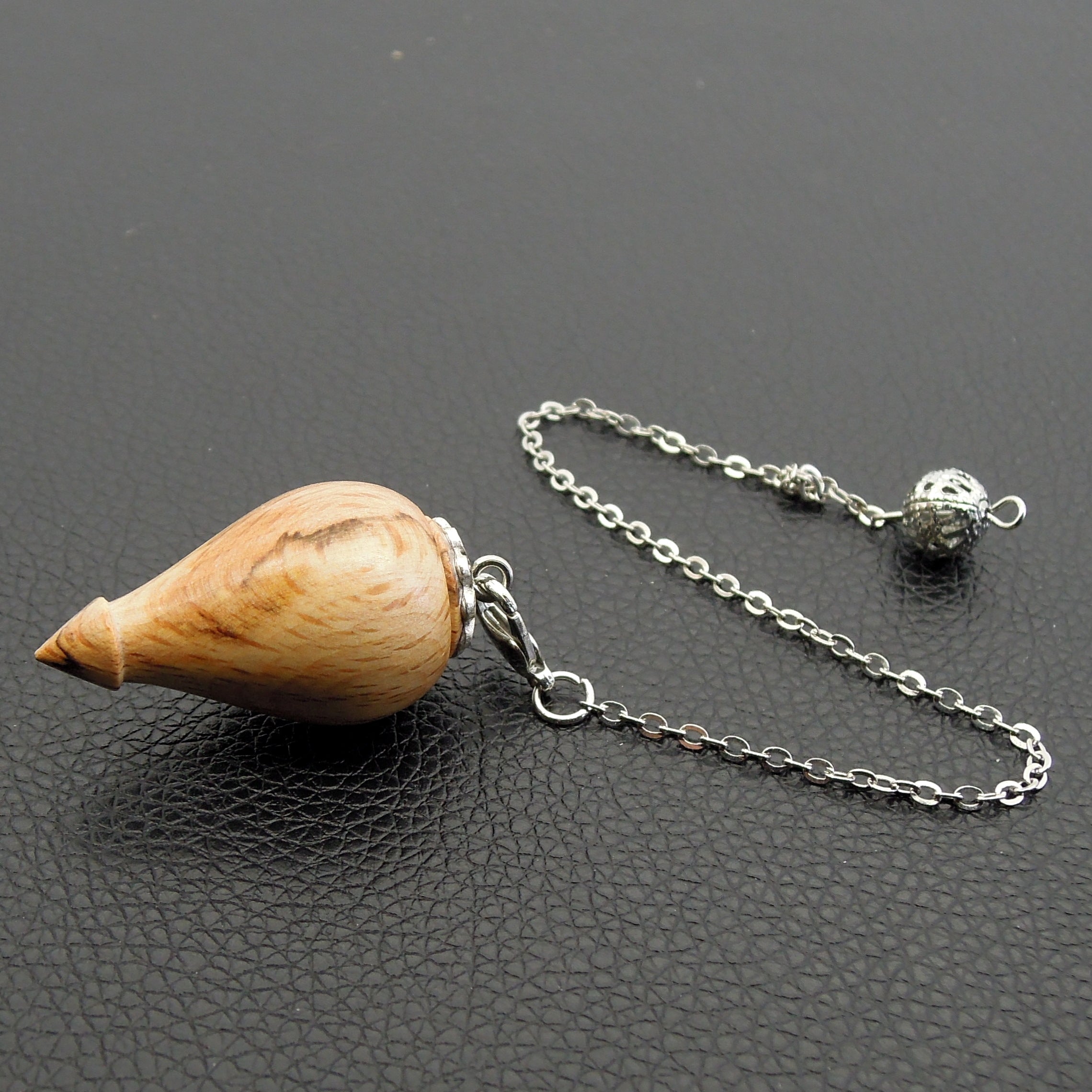 Pendule artisanal de radiesthésie en hêtre échauffé avec chainette et calotte.