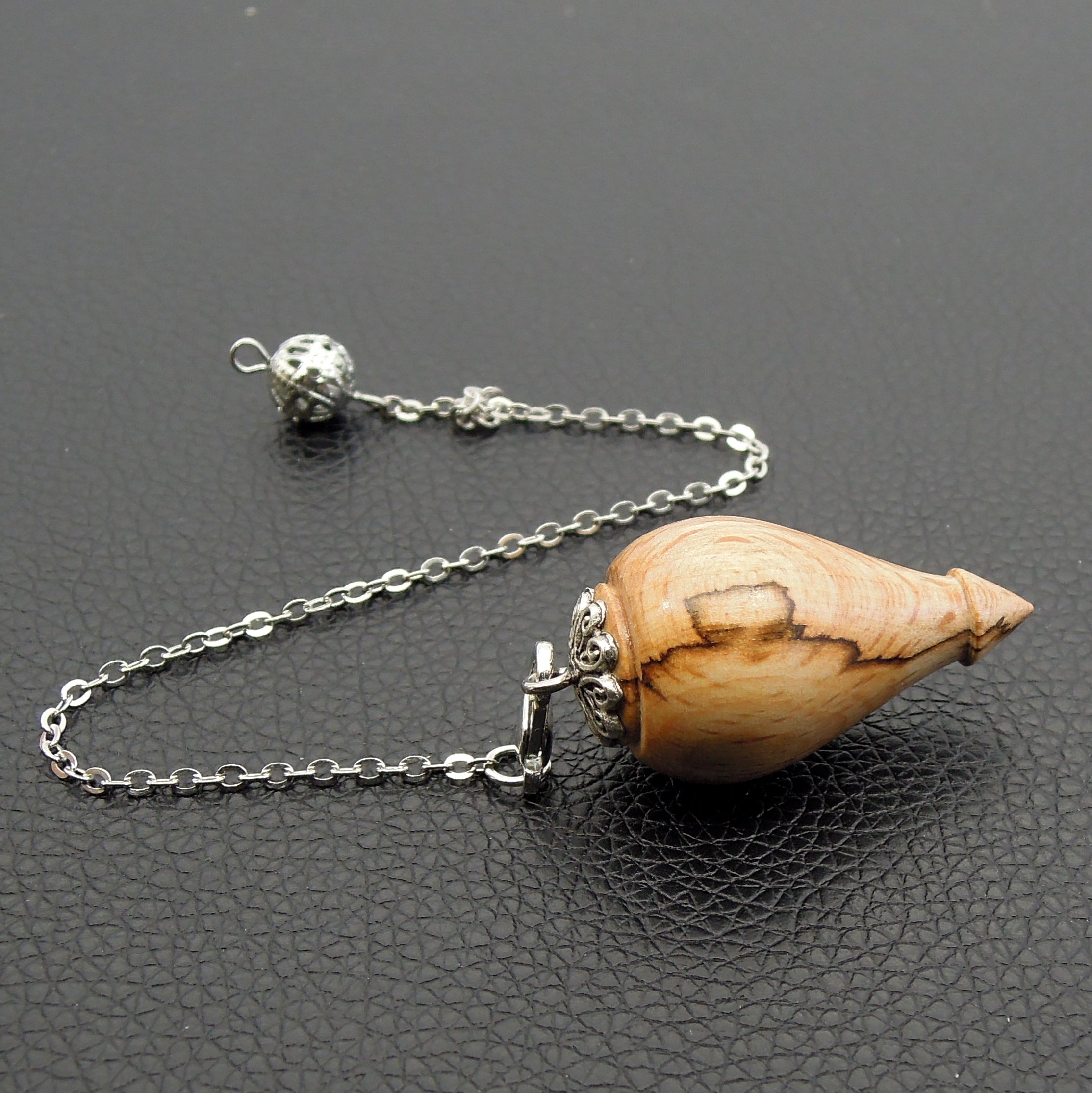 Pendule artisanal de radiesthésie en hêtre échauffé avec chainette et calotte.
